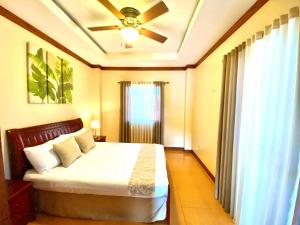 um quarto com uma cama e uma ventoinha de tecto em Elaine's Homestay em Dumaguete