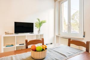 a bowl of fruit on a table with a television at Virginia Apartments in Parma