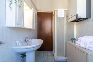 a white bathroom with a sink and a mirror at Virginia Apartments in Parma +11 photos