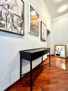 un pianoforte nero in una stanza con foto sul muro di Inn Sistina Home a Roma