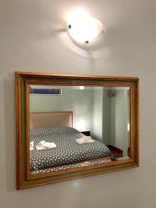 uno specchio a parete con un letto. di Inn Sistina Home a Roma