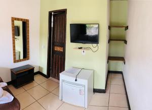 um quarto com uma televisão numa parede com um frigorífico em Pousada Três Corações em Arraial d'Ajuda mais 14 fotografias