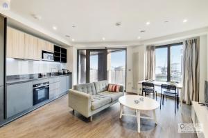 uma sala de estar com um sofá e uma mesa em Deluxe One Bed Apartment by London ExCeL em Londres