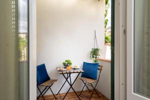 a small table with two blue chairs in a room at Affittacamere Z&I in Florence