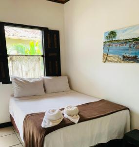 um quarto com uma cama com duas toalhas em Pousada Três Corações em Arraial d'Ajuda