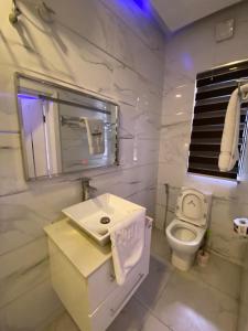 a white bathroom with a sink and a toilet at 2-Bedroom Apartment in Ikoyi in Lagos