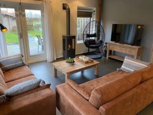 巴勒姆Ballumerhoeve Skip lodge的客厅配有2张棕色沙发和电视