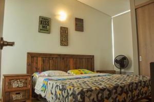 ein Schlafzimmer mit einem Bett mit einem Kopfteil aus Holz in der Unterkunft Apartamento completo tipo vintage en villeta in Villeta