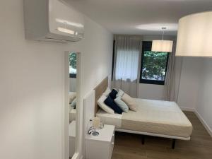 una camera da letto con letto, cuscini e specchio di Apartamento Central E a Algeciras