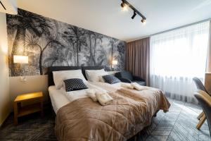 ザモシチにあるHotel Jubilatの壁画のあるベッドルーム1室(大型ベッド1台付)