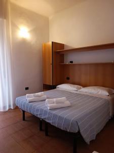 una camera da letto con un letto con due asciugamani sopra di HOTEL VILLA ELISA a Rimini