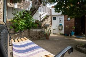 a bench with a blanket on it in front of a house at Casa do Guardado in Monsanto