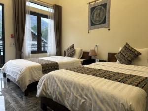 ein Hotelzimmer mit 2 Betten und einem Fenster in der Unterkunft Duong Thim Homestay Mai Chau in Mai Châu
