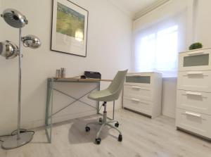 biuro z biurkiem z krzesłem i lampką w obiekcie Covadonga Suite Home w Sewilli