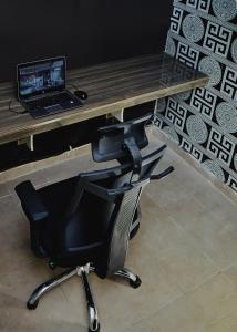 a desk with a chair with a laptop computer on it at Mainstream Shortlet Apartment Ltd in Gbogije