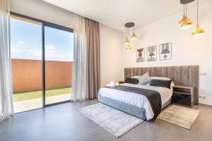 - une chambre avec un lit et une grande fenêtre dans l'établissement Villa Menara, personnels inclus, à Marrakech
