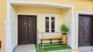 a house with two doors and a bench on the porch at Mainstream Shortlet Apartment Ltd in Gbogije