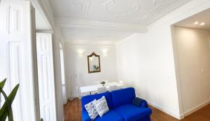 a blue couch in a room with a white ceiling at House On The Hill Lisbon in Lisbon