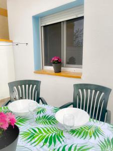 a table with two chairs and a table with plates and flowers at La Casa d Octàvia - Delta de l Ebre in Deltebre