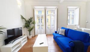 a living room with a blue couch and a tv at House On The Hill Lisbon in Lisbon