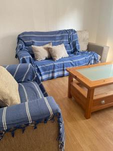 a living room with a blue couch and a coffee table at La Casa d Octàvia - Delta de l Ebre in Deltebre