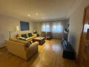 ein Wohnzimmer mit einem Sofa und einem Tisch in der Unterkunft Good Vives Free SL in Madrid