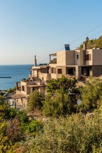 a house on a hill next to the ocean at Villa Cavo d' Oro in Korissia