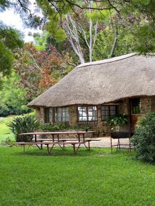 a stone building with a picnic table and a hut at Waterberg Cottages, Private Game Reserve in Vaalwater