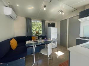 a small living room with a blue couch and a table at Camper Village in Santo Stefano al Mare