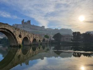 een brug over een rivier met een kasteel op de achtergrond bij Beautiful Art Lovers Apartment in Béziers