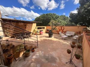 eine Terrasse mit Topfpflanzen sowie einem Tisch und Stühlen in der Unterkunft Le Jardin des vignes in Canet-en-Roussillon