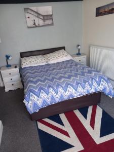 a bedroom with a bed with a red white and blue comforter at Saracens Head The Annex in Skegness