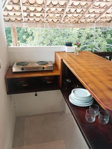 a kitchen with a stove and plates on a table at Alto Amor in Atins