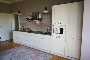 a kitchen with white cabinets and a stove top oven at Villa Rosa - Sky in Detmold