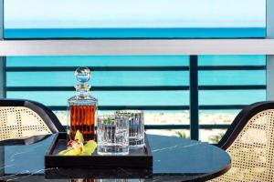 a table with a bottle of alcohol and glasses on it at The Ritz-Carlton South Beach in Miami Beach