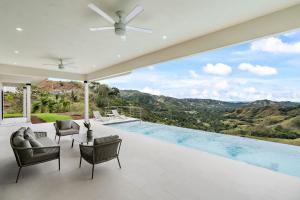 Casa con piscina con sillas y ventilador de techo. en Mountaintop 4-Bedroom with Pool Huge Views, en Carpintero