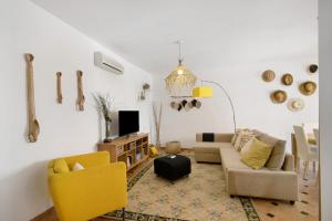 a living room with a couch and chairs and a tv at Mare Cheia in Santa Luzia