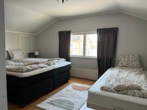 a bedroom with two beds and a window at Villa Suntinhovi in Kokkola