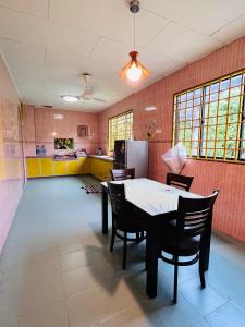 a kitchen with a table and chairs in a room at MH Homestay No2 at Alor Setar in Alor Setar