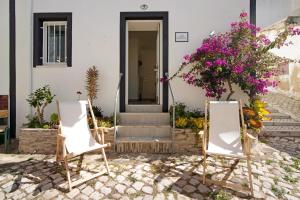 two chairs in front of a house with flowers at Casa Barroca in Alte