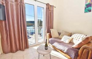 a living room with a couch and a large window at River Beach House in Mesongi