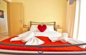 a bedroom with a red heart pillow on a bed at River Beach House in Mesongi