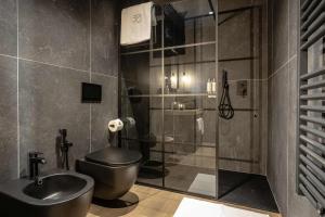 La salle de bains est pourvue de toilettes, d'un lavabo et d'une douche. dans l'établissement AR Prestige Penthouse - TriBeCa Loft, à Bergame