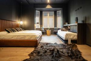 um quarto com 2 camas e um tapete em AR Prestige Penthouse - TriBeCa Loft em Bérgamo