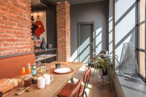 AR Prestige Penthouse - TriBeCa Loft في بيرغامو: طاولة خشبية على شرفة مع جدار من الطوب
