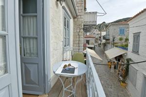 a balcony with a white table and a white chair at Centrál in Hydra