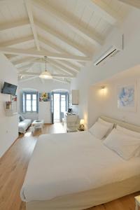 a bedroom with a large white bed in a room at Centrál in Hydra