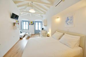a white bedroom with a bed and a living room at Centrál in Hydra