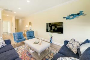 a living room with blue furniture and a flat screen tv at Emerald Isle Vacation Home Walk to Beach! in Emerald Isle