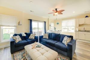 a living room with blue couches and a ceiling fan at Emerald Isle Vacation Home Walk to Beach! in Emerald Isle